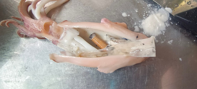 一名網友買小卷回家吃，剖開來卻看見一支香菸。（圖／翻攝自爆廢公社公開版）