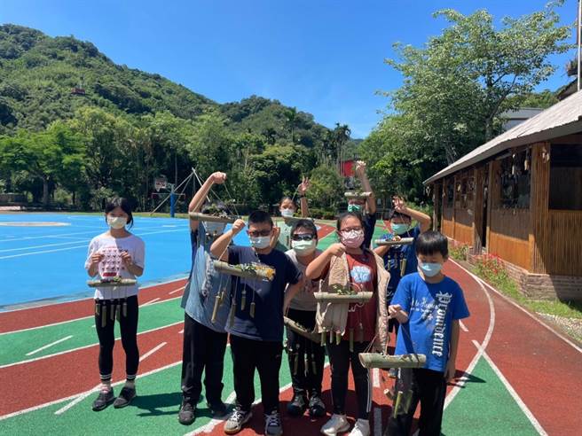 新北市客家局投入320万预算，在五寮里客家庄成立驻地工作站，驻地团队近期特别与在地竹艺大师赖世勇合作，深入五寮国小授课，教导学生利用五寮在地孟宗竹及桂竹，创作结合风铃功能的实用花器，扎根客家文化。（客家局提供）