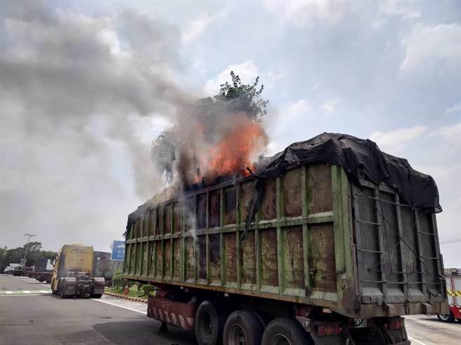 一輛載運報廢車殼回收物的大貨車，今天中午行經國道1號南下新營段時，車斗突然冒出濃煙，駕駛趕緊進入新營休息站停放。（讀者提供／張毓翎台南傳真）