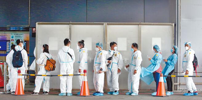 桃园机场第一航厦外的採检站，刚入境的旅客依序排队採检。（范扬光摄）