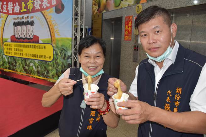 头份市长罗雪珠及市代张家荣示范客家传统吃法，酱油沾吃客家糍粑。（谢明俊摄）