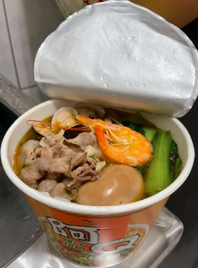 仔细一看可以发现泡麵上不只有最基本的青菜、肉片，还有蛤蜊、虾子等海鲜，相当丰富。（翻摄自Dcard）