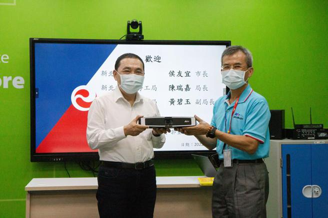 （圆展捐赠50台4K视讯会议系统AVer VB130给新北市政府，协助市府打造完善且高效率的行政沟通环境。图右为圆展董事长郭重松，图左为新北市市长侯友宜。图／圆展提供）