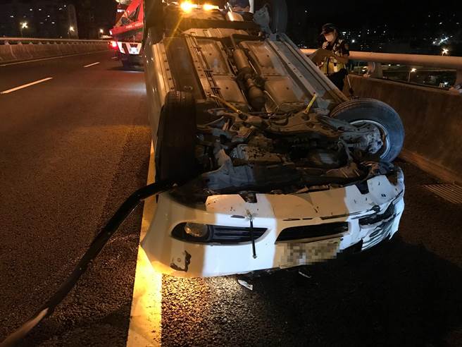 1辆白色自小客车，今天凌晨0时许，在国道1号汐五高架南下32.9公里五股路段翻覆。（警方提供）