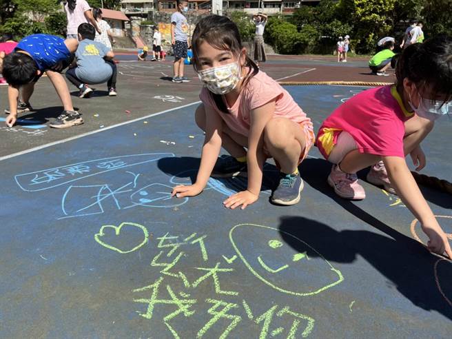 学生在地上涂鸦告别旧操场。（万里国小提供）
