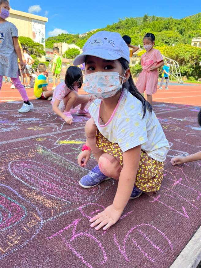 学生在地上涂鸦告别旧操场。（万里国小提供）