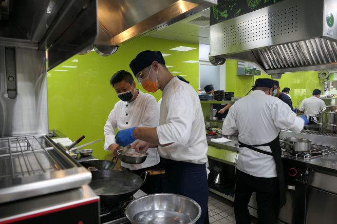 飨宾餐旅总经理陈毅航，到每组参赛伙伴的料理台边，瞭解料理过程并为他们加油打气。(醒吾科大提供)