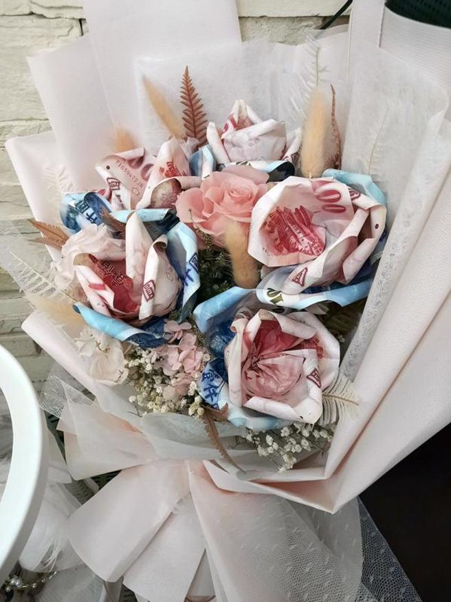  台中市警察局30日公布今年1月间查获以张姓女子为首的贩毒集团，警方并在张女住处起出点钞机，以及用新台币纸钞折成的花束等。（图/ 中央社）