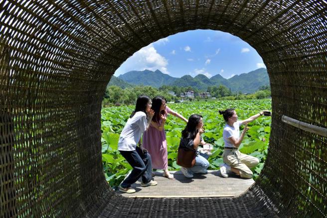 大陆接连调整疫情防控方案，在各项与旅游相关政策消息刺激下，暑期旅游市场一夜之间猛然復甦。有旅行社员工表示，天天加班到凌晨3点，预订跟团游的人多了5、6倍。（图／新华社）