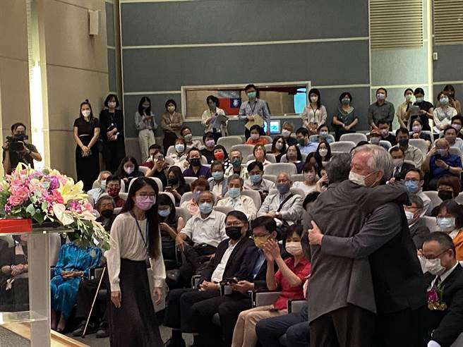 国立台湾美术馆长廖仁义（前左），与原国美馆长梁永斐（前右）完成交接典礼后，台下2人互拥鼓励，现场掌声如雷，场面温馨。（张妍溱摄）