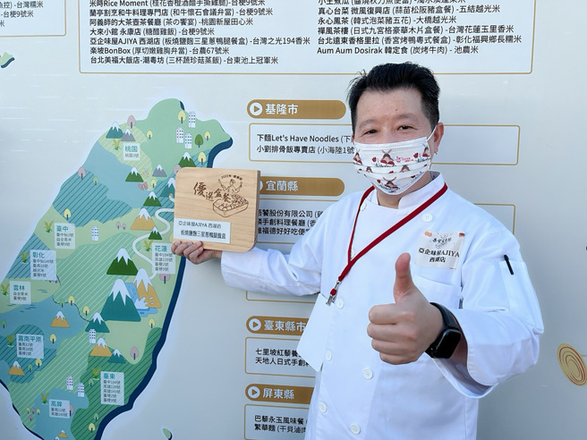 亚企味屋行政总主厨吴进旺领奖后，开心拿着奖牌在活动背板前留影。（摄影/王雅芬）
