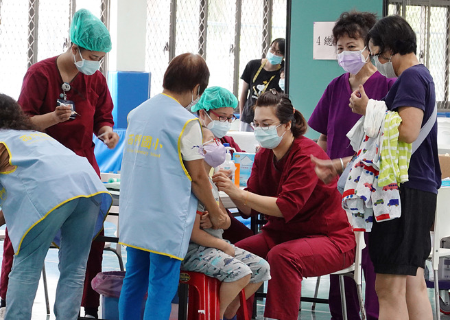 兒童第2劑輝瑞疫苗2日在校園施打，孩童在醫護及家長的合力協助下，矇住雙眼接種疫苗。（張鎧乙攝）