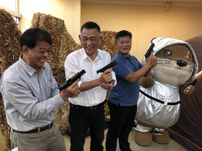 楊鎮浯縣長偕金寧鄉長楊忠俊、金湖鎮長陳文顧「玩槍」，展現歡愉童心的另一面。（李金生攝）