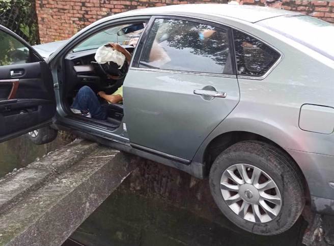怎麼開的？台南六甲傍晚傳出一起車禍，駕駛撞上大排水溝，只靠搖搖欲柱水泥柱支撐，駕駛受困車內，相當驚險。（讀者提供／曹婷婷台南傳真）