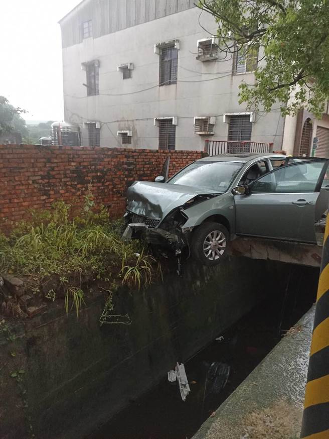 怎麼開的？台南六甲傍晚傳出一起車禍，駕駛撞上大排水溝，只靠搖搖欲柱水泥柱支撐，駕駛受困車內，相當驚險。（讀者提供／曹婷婷台南傳真）