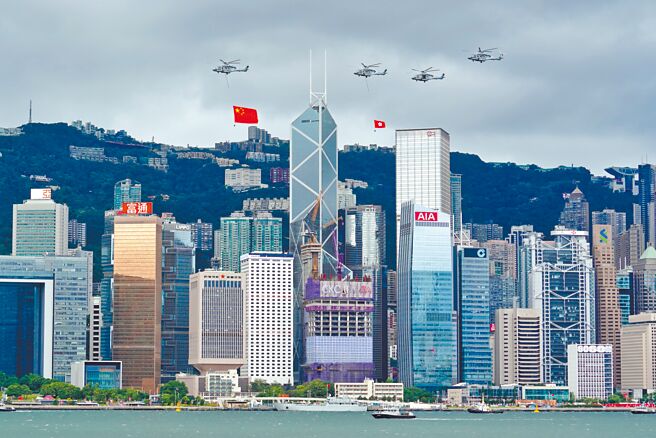 香港新一届政府7月1日宣誓就职。图为1日早晨，分别悬挂大陆五星旗和香港区旗的直升机编队飞过维多利亚港上空。（中新社）