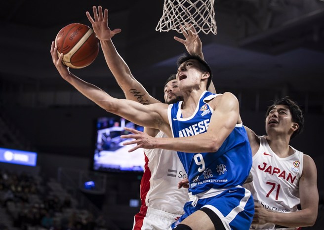 唐维杰（前）在两名日本队球员防守下奋力挑战篮框。（取自FIBA官网）