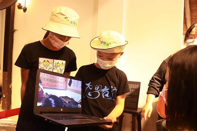 小小导览员（中）带领群眾参观活字版印刷，吸引小朋友观看。（实习摄影记者谢家瑀摄）