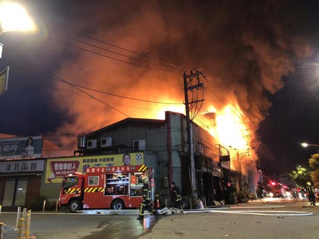  桃園市中壢區培英路一處鐵皮連棟的兩層樓殯葬服務業公司住宅4日凌晨發生火警，猛烈火勢燒毀6間從事殯葬業的禮儀公司，且不斷冒出濃煙，消防人員抵達現場後，立即拉水線進行搶救。（圖/ 中央社）
