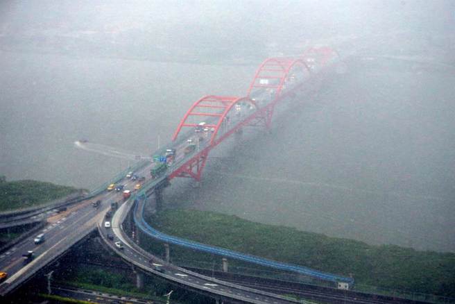 受到西南風影響，台灣大氣環境5日仍然相當不穩定，上午台南、高雄、屏東及恆春半島持續有陣雨或雷雨發生，加上午後熱對流發展旺盛，午後雷陣雨雨區擴大，瞬間大雨降落在觀音山附近，頓時影響正在行車民眾的視線。（鄧博仁攝）
