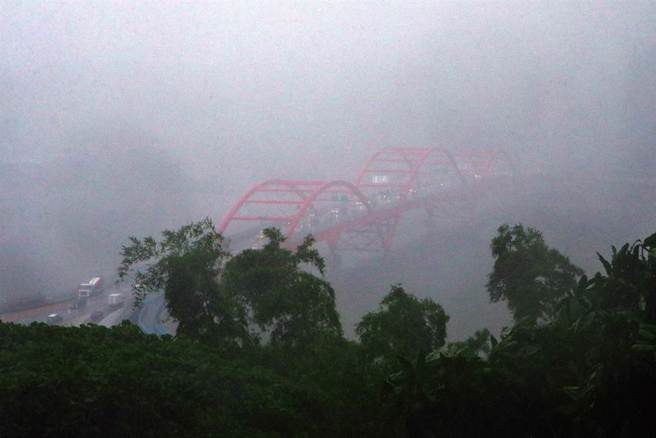 受到西南風影響，台灣大氣環境5日仍然相當不穩定，上午台南、高雄、屏東及恆春半島持續有陣雨或雷雨發生，加上午後熱對流發展旺盛，午後雷陣雨雨區擴大，瞬間大雨降落在觀音山附近，頓時影響正在行車民眾的視線。（鄧博仁攝）
