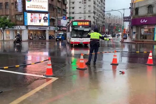 桃园市桃园区龙寿街、经国路一带5日因午后大雨造成积水，员警到场后立即摆设交通锥并进行交通管制，大雨造成的排水宣泄不及现象，大约在20分钟后就消退，但桃园警分局员警仍在现场指挥交通，避免意外发生。（图/ 中央社）