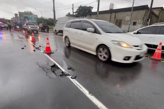 桃园市桃园区龙寿街、经国路一带5日因午后大雨造成积水，约20分钟后虽消退，但部分路段路面出现坑洞，员警到场进行交通疏导。（图/ 中央社）