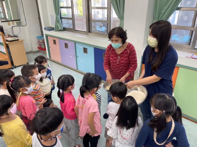 简叶真秀厨工(红衣)配合教学介绍营养午餐食材来源。(图/新北市政府)
