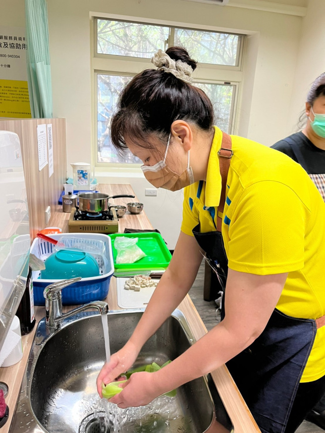 台灣關懷弱勢家庭協會理事長鄭賢美認真執行備餐後的清洗流程。(圖/聖約翰科技大學提供)