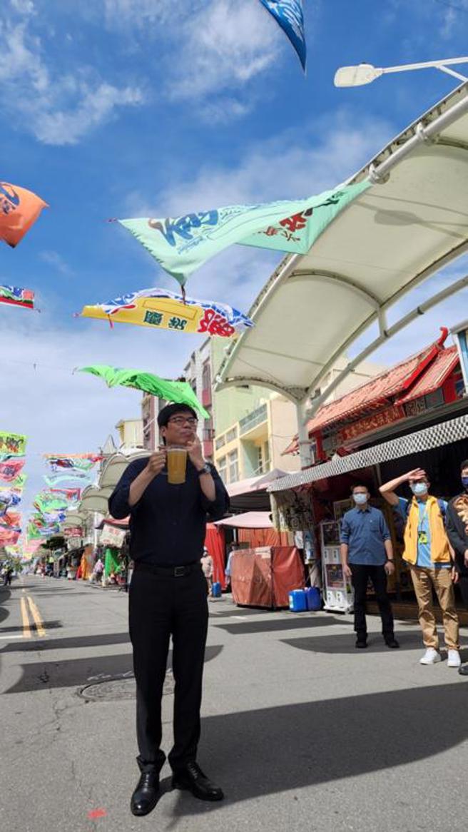  高雄市长陈其迈（前）6日前往旗津宣传周末起将开跑的黑沙玩艺节跟啤酒嘉年华，并向现场媒体展示嘴上的啤酒泡沫。（图/ 中央社）