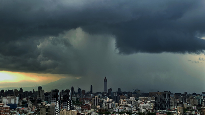 6日傍晚下班用餐时刻，西边夕阳仍有余晖，但北市部分地区的天空却涌起一片乌云，再度下起雨瀑。（姚志平摄）