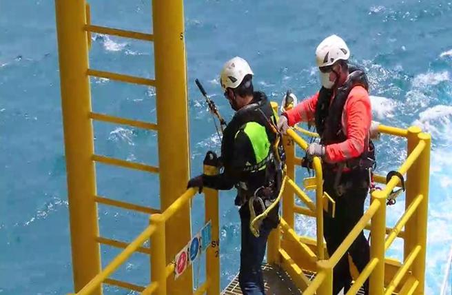 （劳动检查员检查垂直爬梯卷扬式防坠器状况。图／职安署提供）