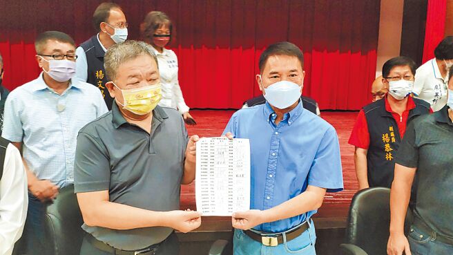 身兼全国正副议长联谊会总会长的新北市议长蒋根煌（左），5日带队声援苗栗议长锺东锦，蒋根煌拿出全国正副议长签名的连署书，展现力挺锺东锦的决心。（李京升摄）