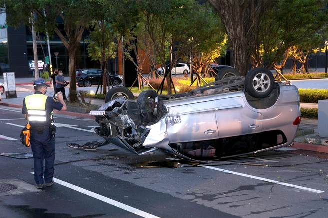 銀色廂型車自撞翻覆，車損嚴重，警方到場調查釐清。（黃世麒攝）