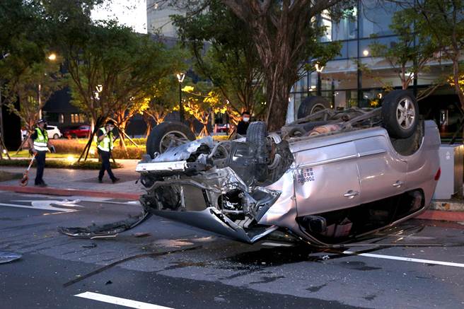銀色廂型車自撞翻覆，車損嚴重，警方到場調查釐清。（黃世麒攝）