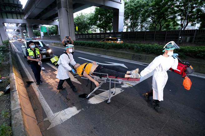 醉男倒在环东大道旧宗路闸道处，员警叫不醒他，只能请救护车先将他送医。（黄世麒摄）