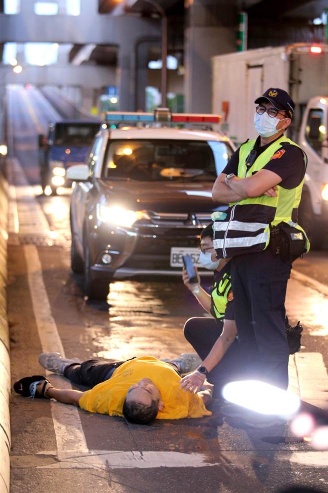醉男倒在环东大道旧宗路闸道处，还叫不醒，让员警相当无奈。（黄世麒摄）