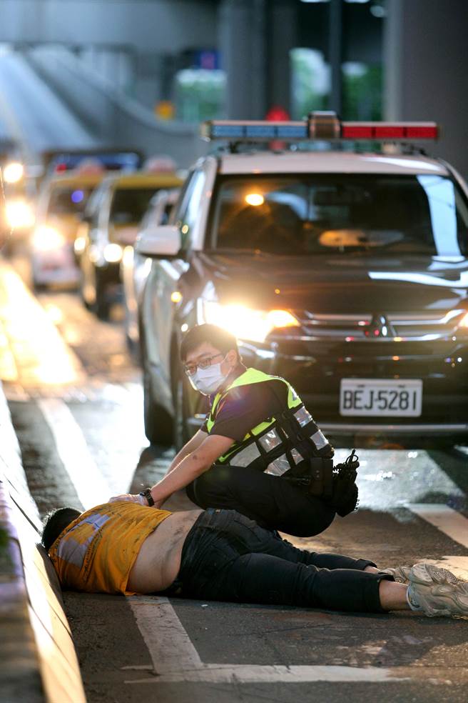 醉男倒在环东大道旧宗路闸道处，还叫不醒，让员警相当无奈。（黄世麒摄）