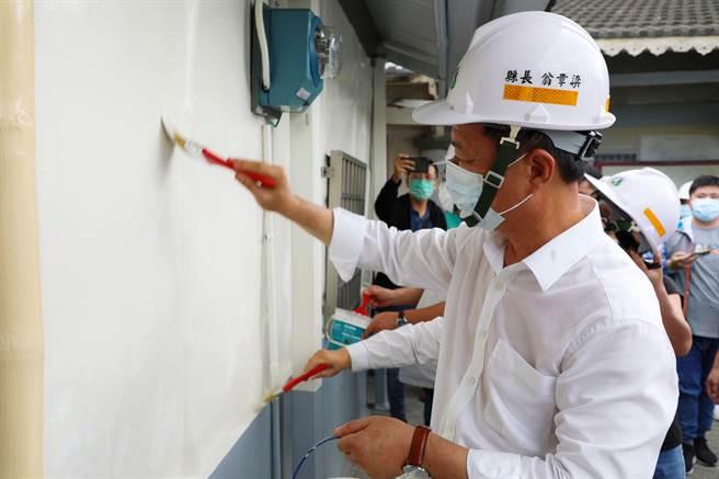 嘉义县长翁章梁为施姓案家的房子做最后粉刷补强。（廖素慧摄）