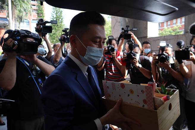 林智坚将新竹市府局处同仁欢送小礼放入后车厢，表情伤感。（邱立雅摄）