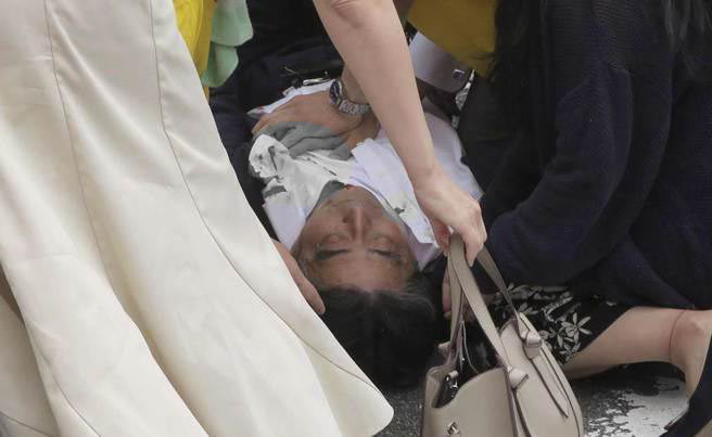 日本前首相安倍晉三背後遭霰彈槍突襲，血流不止。（美聯社）