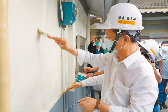 嘉义县长翁章梁为施姓老翁的房子做最后粉刷补强。（廖素慧摄）