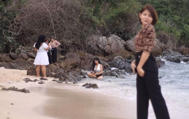 男帮女友拍照却聚焦后方的比基尼辣妹，引来万人朝圣。（图／翻摄自Facebook／Jakapong Thongdee）