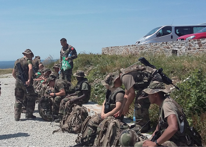 中间站立同袍手里的绿色袋子中便是我们一餐的军粮，包含一小份沙拉、一份薯片、一份肉酱、一小块糕点和一瓶水。看似很多，但我就算吃两份也不会饱。(图/好人出版提供)