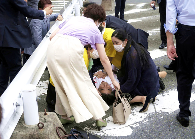 日本前首相安倍晉三8日遭到槍擊倒地，有網友及媒體認為跪在一旁的長髮秀麗女子是有「帶刺玫瑰」之稱女神級隨扈石田萌美。（圖／美聯社、共同社）