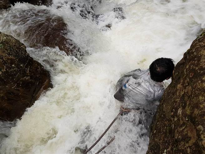 陈姓男子双脚卡在石缝，受困溪水当中。（翻摄照片／李京升苗栗传真）