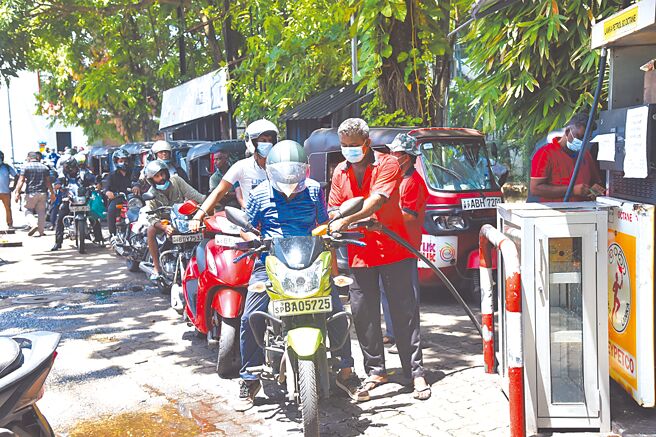 圖為斯里蘭卡首都科倫坡一處加油站附近，民眾排隊加油。（新華社）