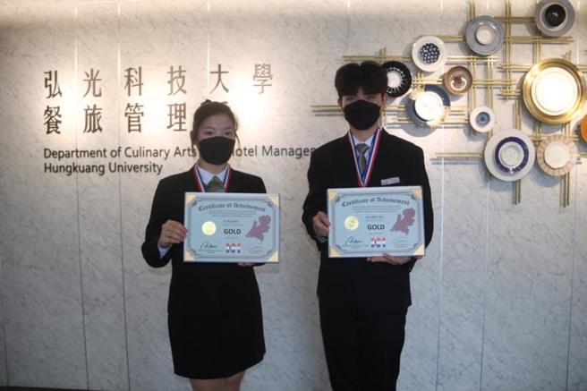 弘光科技大學餐旅管理系大一學生朱俊瑋（右）參加2022年NICC荷蘭國際餐飲線上挑戰賽，跨組報名餐桌服務托盤、口布摺疊兩項比賽，拿到一金一銀；同樣跨組參賽的餐旅系西廚組大一學生陳怡如（左）在餐桌服務口布摺疊奪金。（圖/ 中央社）