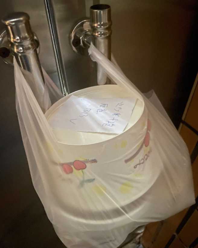 外送員將餐點塑膠袋分別掛在2個門把，不但無法開門，即便顧客強行開門，也會造成餐點「爆裂」。（翻攝自臉書「外送員的奇聞怪事」）