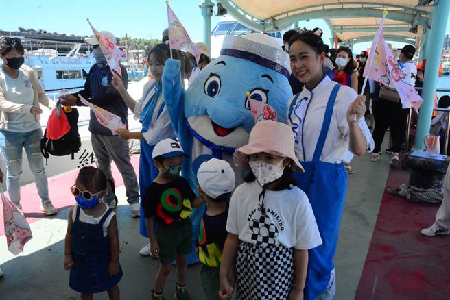 花莲远雄海洋公园吉祥物在花莲港迎接旅客搭船出海赏鲸。（王志伟摄）